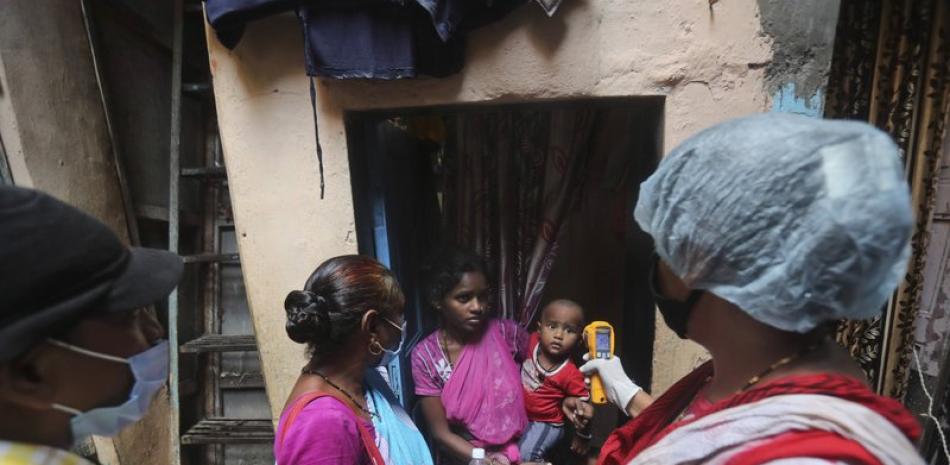 Una trabajadora sanitaria mide la temperatura de residentes en busca de posibles casos de COVID-19 en Dharavi, uno de los mayores barrios pobres de Asia, en Mumbai, India, el 8 de septiembre de 2020. (AP Foto/Rafiq Maqbool)