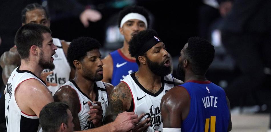 Marcus Morris Sr. de Los Angeles Clippers, segundo desde la derecha, y Paul Millsap de los Denver Nuggets se pelean durante la primera mitad de un partido de baloncesto de semifinales de la conferencia de la NBA, este viernes.
