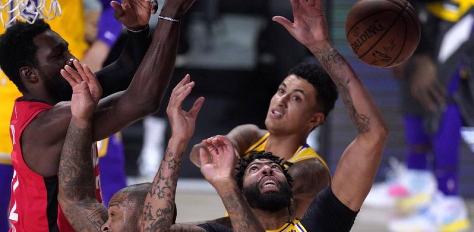 Anthony Davis (3) de Los Angeles Lakers y PJ Tucker, a la izquierda, alcanzan el balón durante la primera mitad de un partido de baloncesto de semifinales de la conferencia de la NBA este jueves.