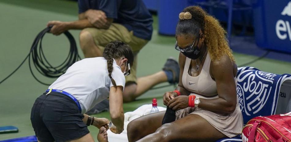 Serena Williams recibe atención de una kinesióloga durante la semifinal del Abierto de Estados Unidos ante la bielorrusa Victoria Azarenka en Nueva York (AP)