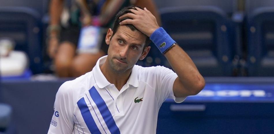 Novak Djokovic, de Serbia, reacciona después de golpear inadvertidamente a un juez de línea con una pelota después de golpearla en reacción a perder un punto contra Pablo Carreño Busta, de España, durante la cuarta ronda del campeonato de tenis del Abierto de Estados Unidos, el domingo 6 de septiembre. 2020, en Nueva York. Djokovic incumplió el partido.
