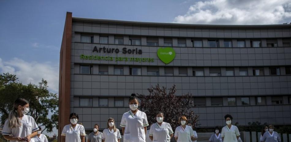 Trabajadores de la residencia para mayores DomusVi Arturo Soria guardan un minuto de silencio en apoyo del personal del sector sanitario y social, en Madrid, el 15 de septiembre de 2020. (AP Foto/Manu Fernández)