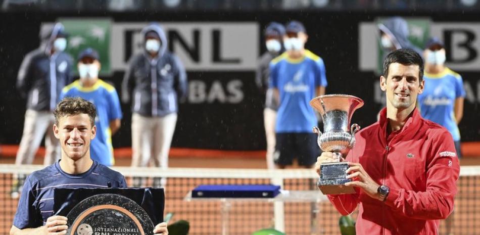 El campeón Novak Djokovic (derecha) exhibe su trofeo tras vencer a Diego Schwartzman (izquierda) en la final del Abierto de Italia.