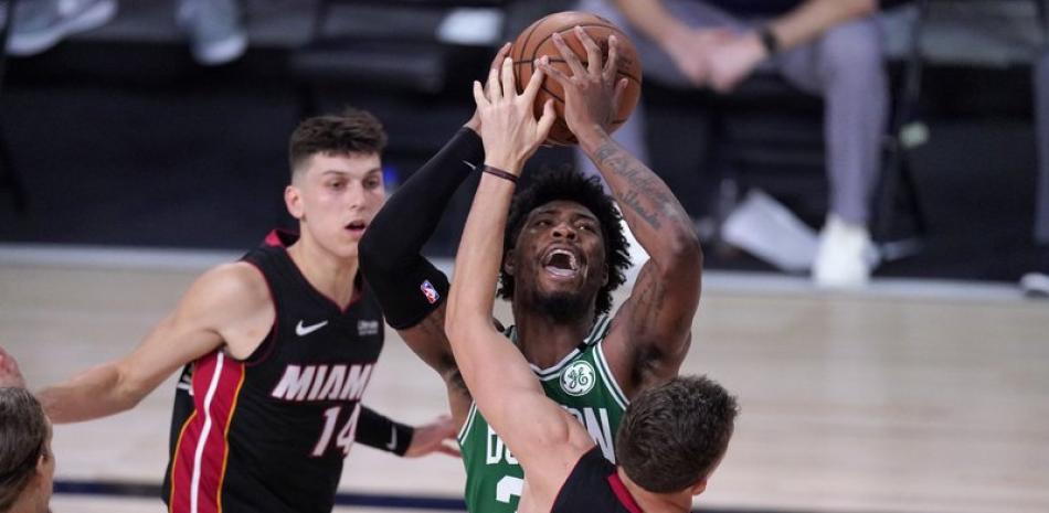 Kelly Olynyk (izquierda) y Duncan Robinson del Heat de Miami defienden mientras el base de los Celtics de Boston Marcus Smart trata de hacer un tiro durante la segunda mitad del juego de la NBA, el sábado .