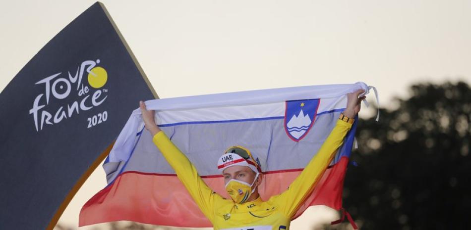 El campeón del Tour de Francia Tadej Pogacar despliega la bandera de Eslovenia tras el final de la última etapa en París, este domingo  (AP Foto/Christophe Ena)