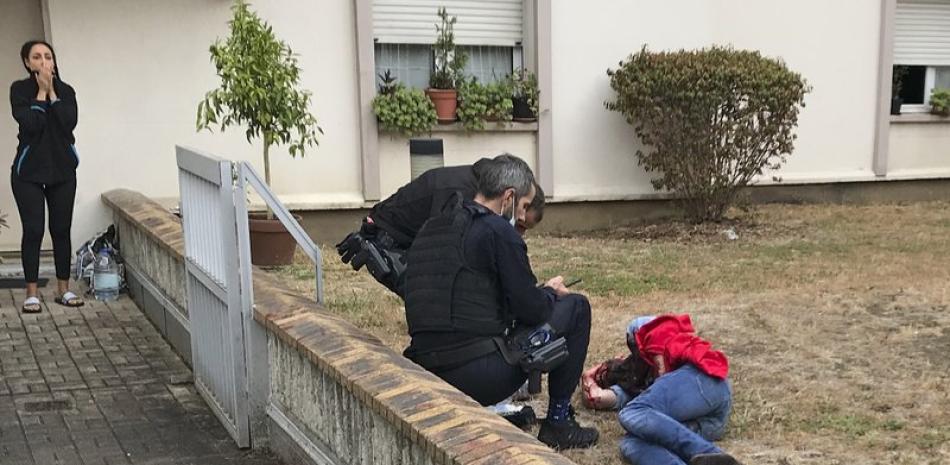 Un hombre que se encuentra en el suelo es auxiliado después de que fuera herido durante un ataque con arma blanca en París, el viernes 25 de septiembre de 2020. (David Cohen vía AP)