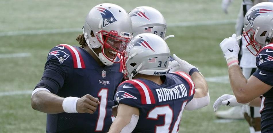 El mariscal de campo de los New England Patriots, Cam Newton (1), celebra su pase de touchdown al corredor Rex Burkhead (34) en la primera mitad de un juego de fútbol americano de la NFL contra los Raiders de Las Vegas.