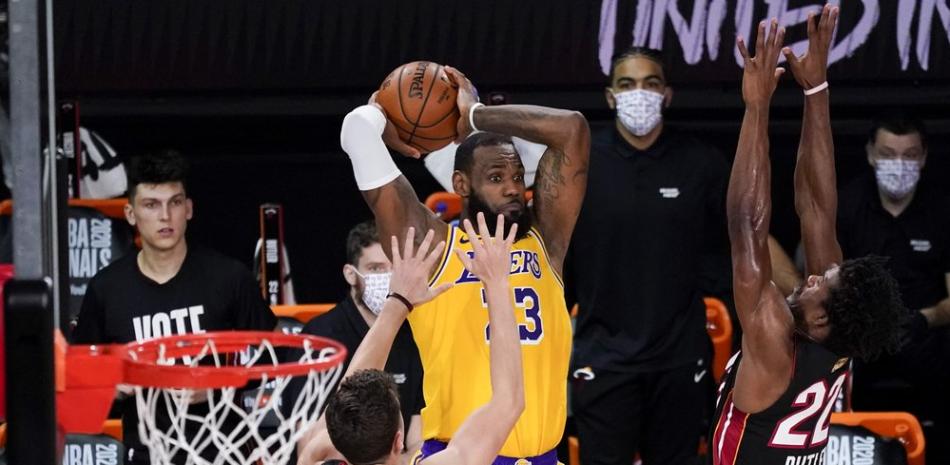 El alero de Los Angeles Lakers, LeBron James, pasa entre el escolta del Miami Heat, Duncan Robinson, a la izquierda, y el alero Jimmy Butler durante la segunda mitad del Juego 4 de las Finales de la NBA, este martes.