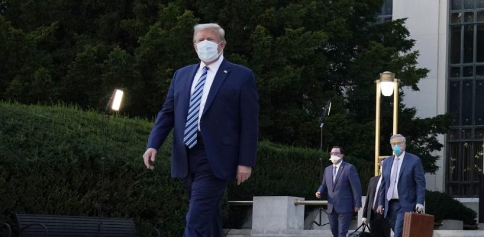 Donald Trump fotografiado a la salida del hospital militar donde estuvo internado tres días tras detectársele el COVID-19. Foto: AP/Evan Vucci.