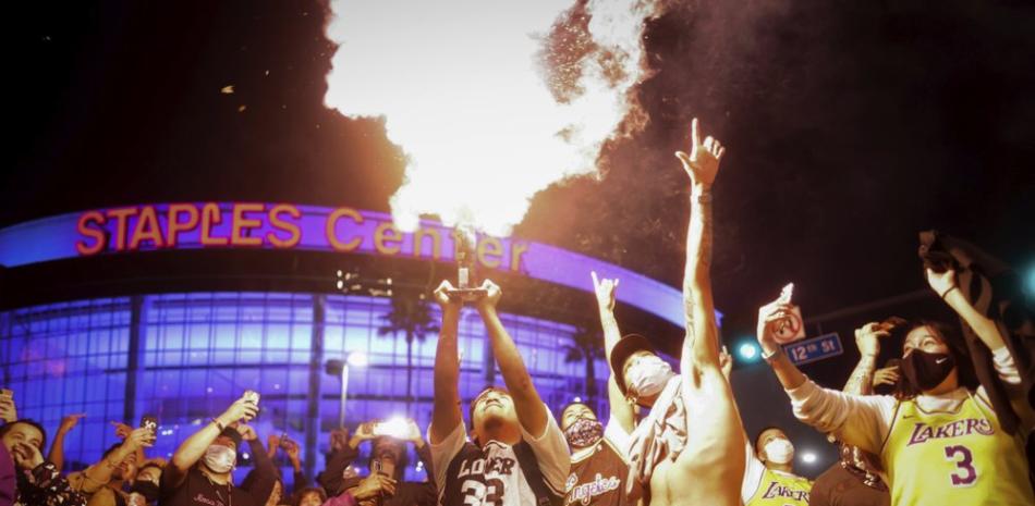 Los fanáticos de Los Angeles Lakers celebran fuera del Staples Center, el domingo 11 de octubre de 2020, en Los Ángeles, después de que los Lakers derrotaran al Miami Heat en el Juego 6 de las Finales de la NBA de baloncesto para ganar el campeonato.