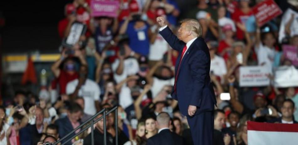 El presidente Donald Trump saluda a la multitud cuando se va después de hablar durante el evento de campaña en el Aeropuerto Internacional Orlando Sanford. Foto: Joe Raedle/AFP.