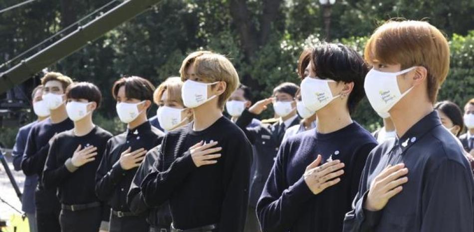 La banda sudcoreana BTS saluda su bandera nacional durante una ceremonia para conmemorar el Día Nacional de la Juventud en la Casa Azul presidencial en Seúl, Corea del Sur, el 19 de septiembre de 2020. (Lee Jin-wook/Yonhap via AP)