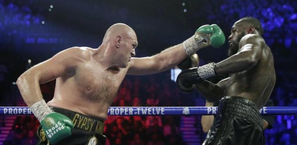 Tyson Fury (izquierda) pelea contra Deontay Wilder en el combate por el cetro pesado del CMB, en Las Vegas.