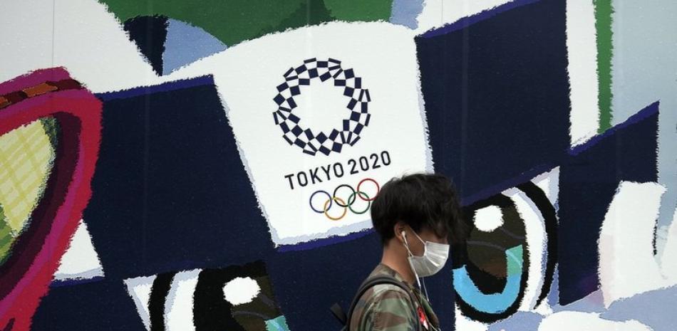 Un hombre camina frente a un anuncio de los Juegos Olímpicos de Tokio 2020 este jueves 8 de octubre de 2020 en Tokio. El tifón Chan-hom se acerca a la isla principal de Japón y las autoridades advierten sobre fuertes vientos y lluvias torrenciales.