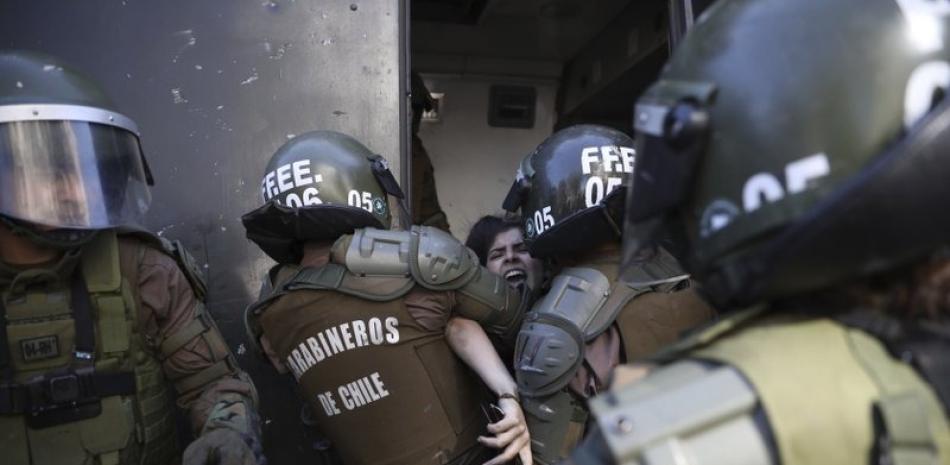 Carabineros chilenos detienen a un manifestante en octubre de este mes en la capital, Santiago. Foto: AP