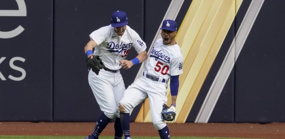 El jardinero derecho de Los Angeles Dodgers Mookie Betts celebra con el jardinero central Cody Bellinger después de robarle un jonrón a Marcell Ozuna de los Bravos de Atlanta durante la quinta entrada.
