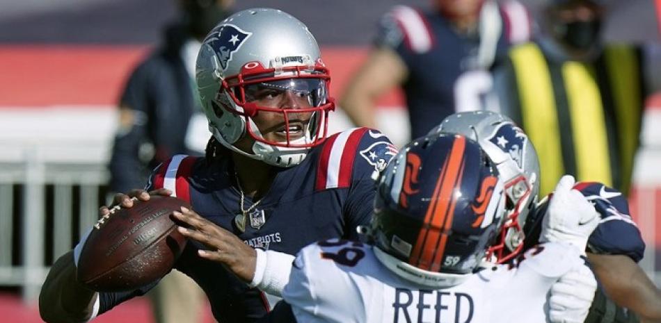 El quarterback de los Patriots de Nueva Inglaterra Cam Newton intenta lanzar el balón mientras lo presiona el linebacker de los Broncos de Denver Malik Reed, este domingo. (AP Photo/Steven Senne)