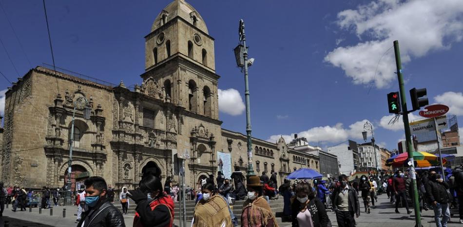 La gente camina en el centro de La Paz el 19 de octubre de 2020, un día después de que el candidato presidencial izquierdista de Bolivia, Luis Arce, del partido Movimiento por el Socialismo, ganara las elecciones generales del país. Jorge BERNAL / AFP