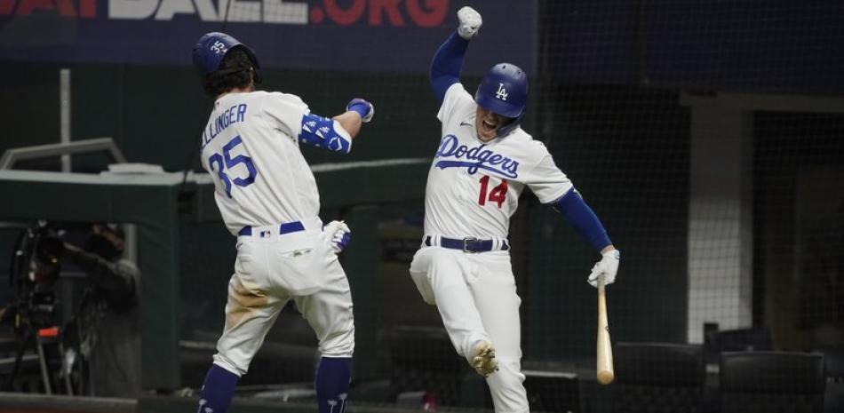 Cody Bellinger, de los Dodgers de Los Ángeles, celebra su jonrón con Kiké Hernández, en el séptimo juego contra los Bravos de Atlanta por el campeonato de la Liga Nacional, el domingo en Arlington, Texas.(AP Foto/Tony Gutierrez)