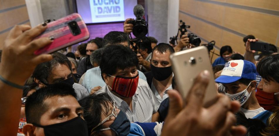 El ex presidente boliviano Evo Morales (C) está rodeado de simpatizantes después de ofrecer una conferencia de prensa en Buenos Aires el 19 de octubre de 2020, un día después de que Bolivia celebrara elecciones presidenciales con su candidato elegido a dedo Luis Arce ganando la votación.

Juan MABROMATA / AFP