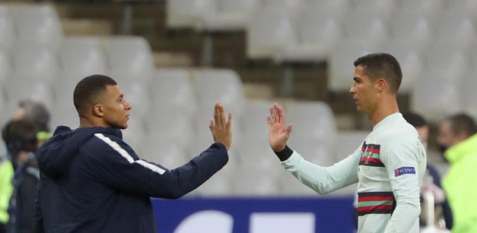 El francés Kylian Mbappé y el portugués Cristiano Ronaldo se saludan previo a un partido amistoso en el Stade de France en Saint-Denis, norte de París. (AP Foto/Thibault Camus, archivo)