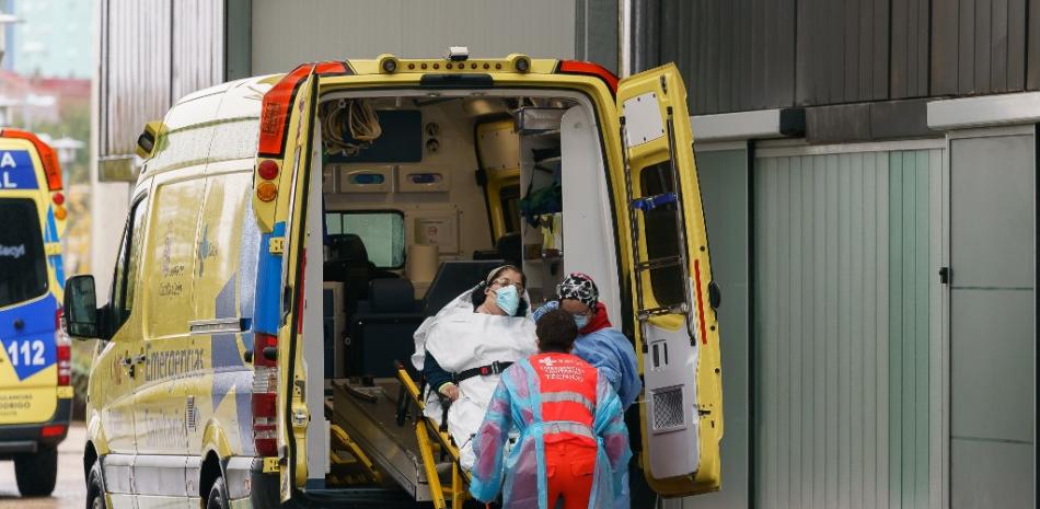 Los paramédicos sacan a una mujer de una ambulancia frente al Hospital de Burgos en Burgos, en el norte de España, el 21 de octubre de 2020, en el primer día de un encierro de dos semanas en un intento por limitar el contagio del nuevo coronavirus COVID-19 en la zona. 
César Manso / AFP
