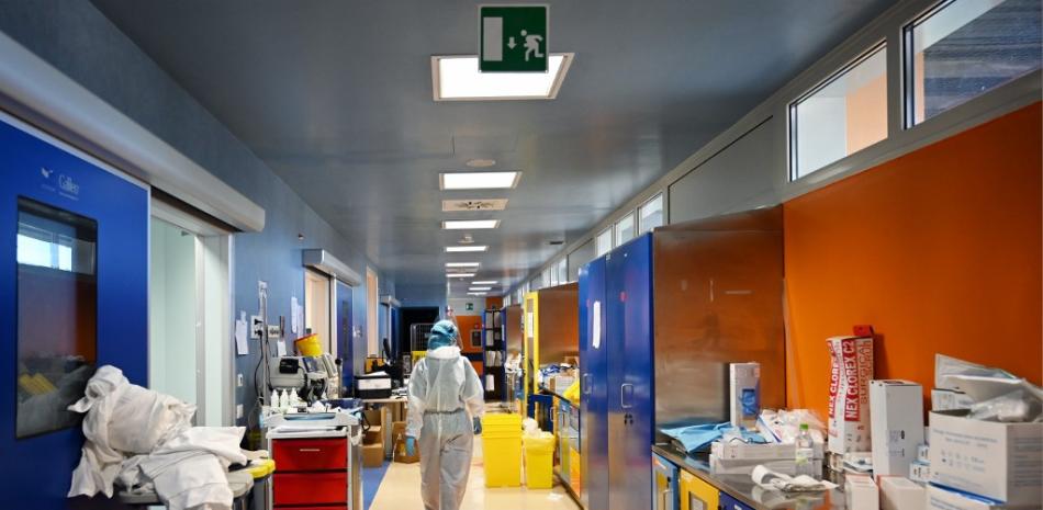 Trabajador médico con equipo de protección personal (EPI) paseando por el pasillo del  nivel-3, Unidad de Cuidados Intensivos (UCI) para casos del nuevo coronavirus, en el hospital Casal Palocco. Alberto PIZZOLI / AFP
