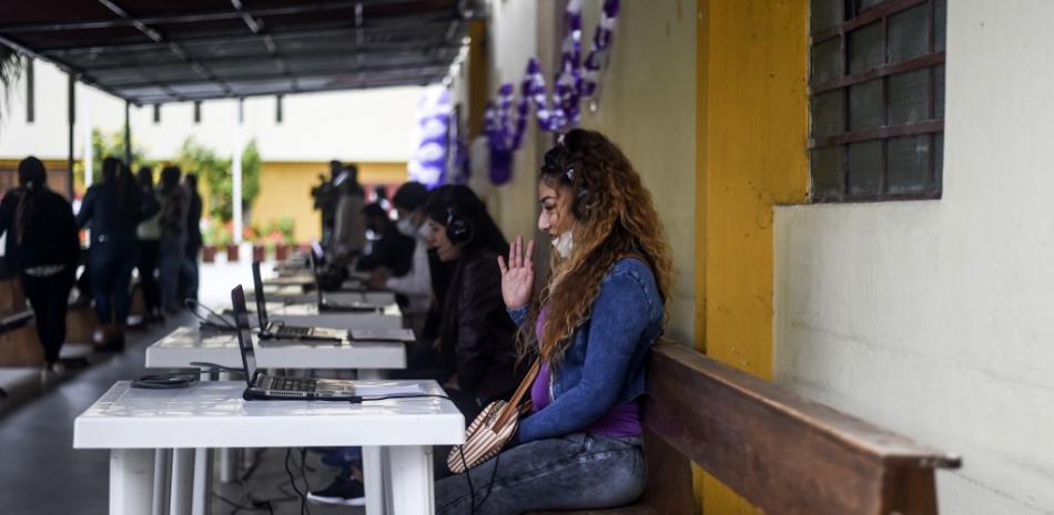 Joselyn Lavado de 28 años, saluda mientras se comunica en línea con sus familiares en la prisión de mujeres de Santa Mónica en Lima, Perú.