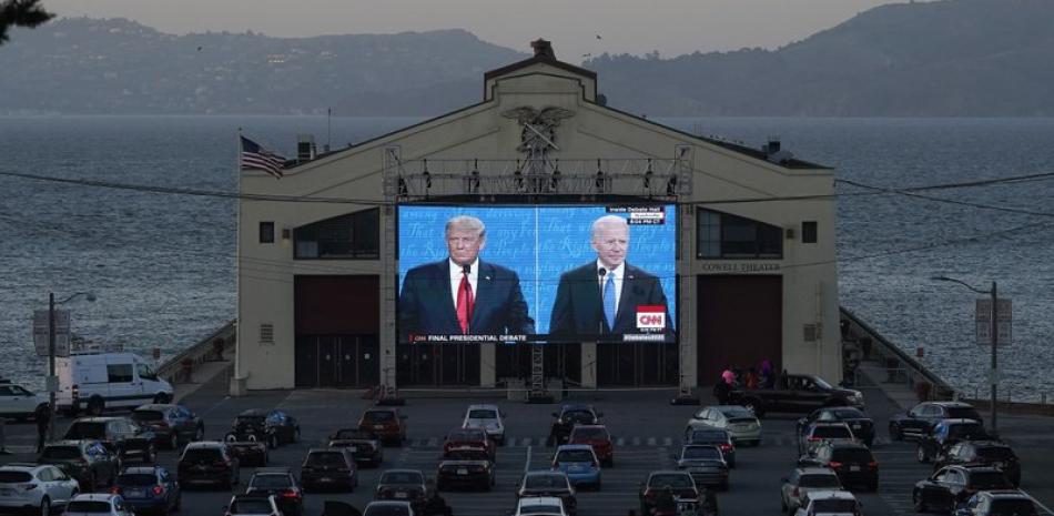 Espectadores siguen el segundo y último debate entre el presidente de Estados Unidos, Donald Trump (a la izquierda en la pantalla), y el aspirante demócrata, el exvicepresidente Joe Biden, en Fort Mason Center, San Francisco, el 22 de octubre de 2020. (AP Foto/Jeff Chiu)