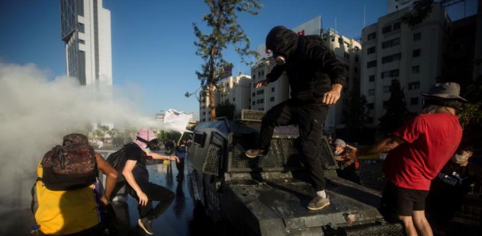 Manifestantes se enfrentan a los carabineros durante una nueva jornada de protestas en contra del gobierno del presidente Sebastián Piñera, en Plaza Italia, en Santiago (Chile). EFE/Alberto Valdés