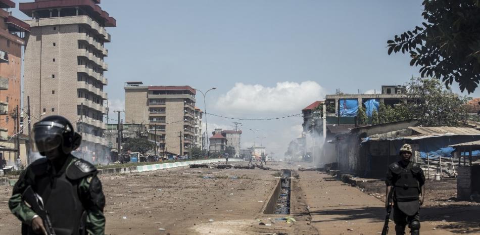 Oficiales de la policía vistos frente a los manifestantes, que continúan arrojando piedras y bloqueando carreteras durante las protestas masivas después de que se publicaron los resultados preliminares.