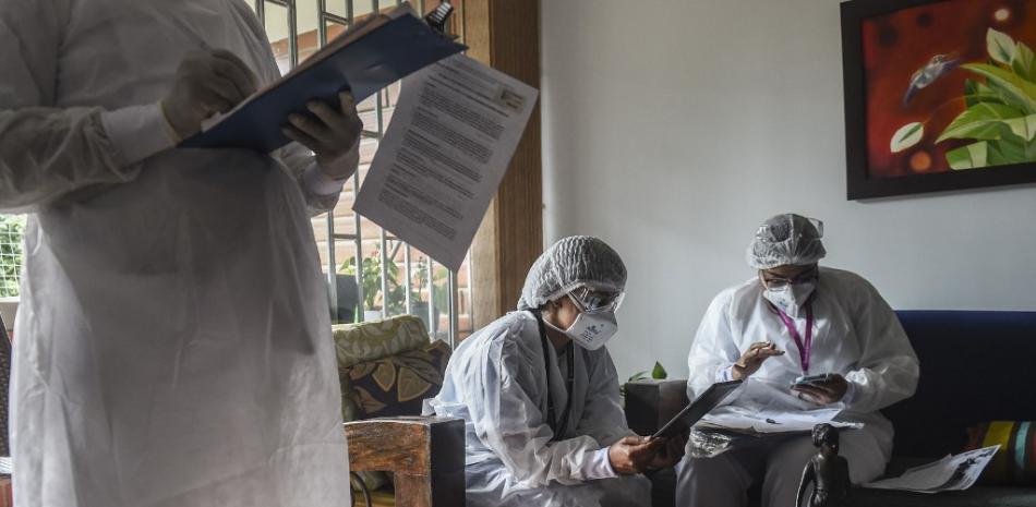 Los trabajadores de la salud realizan una encuesta durante un estudio de prueba de seroprevalencia de COVID-19 en Medellín, Colombia, el 24 de octubre de 2020. JOAQUIN SARMIENTO / AFP