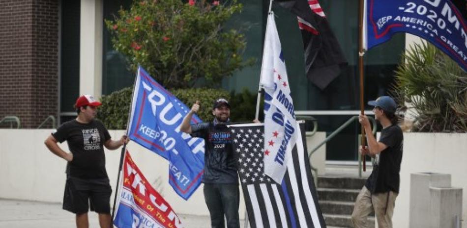 Personas con banderas en apoyo a Donald Trump. / AFP