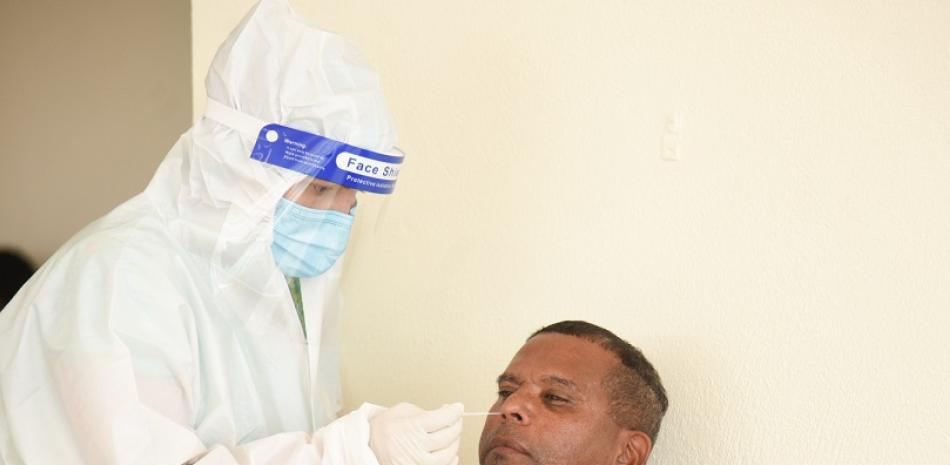 El miembro del Cuerpo Técnico de las Águilas Cibaeñas mientras es sometido a la prueba PCR por personal de Salud Pública.