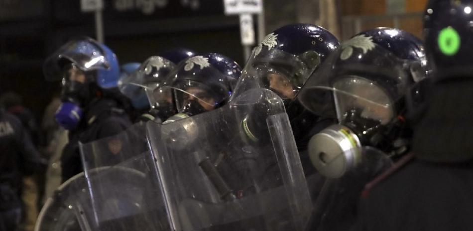 Policías antimotines patrullan durante una protesta contra las restricciones del gobierno para frenar la propagación del COVID-19, en Milán. Foto: AP/Luca Bruno.