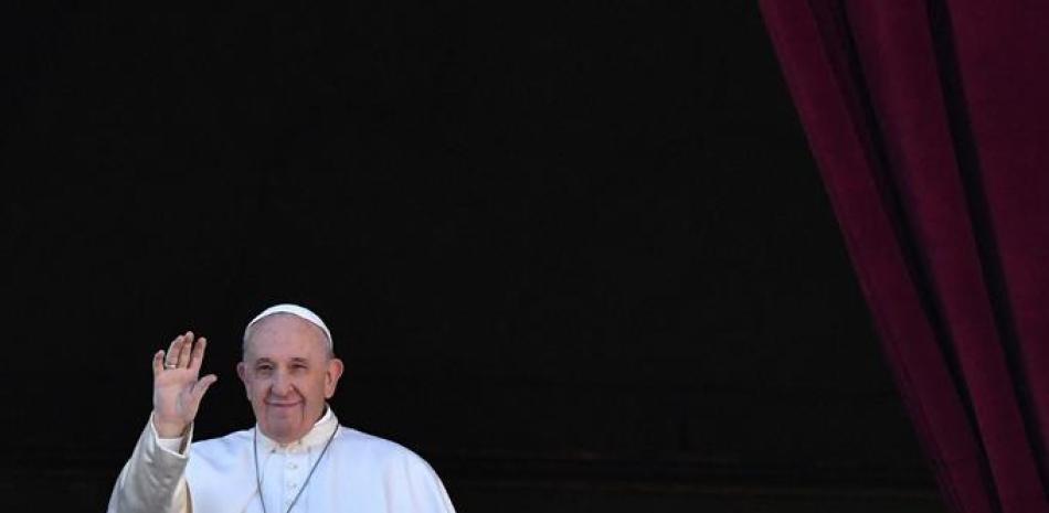 El Papa Francisco saluda desde el balcón de la basílica de San Pedro durante el tradicional mensaje navideño "Urbi et Orbi" a la ciudad y al mundo, en la plaza de San Pedro en el Vaticano. Alberto Pizzoli / AFP