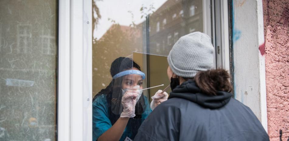 Una mujer es examinada para Covid-19 a través de la ventana de la consulta de un médico en el barrio de Kreuzberg en Berlín, el 21 de octubre de 2020.
STEFANIE LOOS