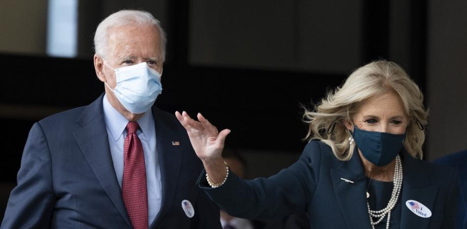 El candidato presidencial demócrata Joe Biden y su esposa Jill Biden saludan mientras salen del Carvel Delaware State Building después de votar en Wilmington.JIM WATSON