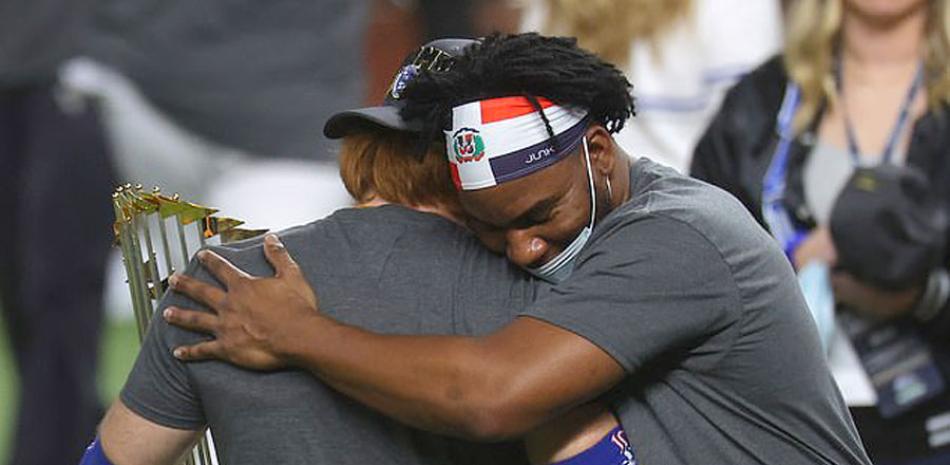 El dominicano Pedro Báez abraza a Justin Turner luego que los Dodgers ganaran la Serie Mundial. Turner fue diagnosticado positivo al Covid antes de concluir el juego.