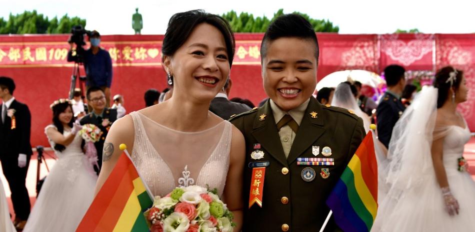 La pareja del mismo sexo recién casada, Yi Wang (derecha) y Yumi Meng, posan para una fotografía durante una boda masiva en el Cuartel General del Comando del Ejército de Taiwán en Taoyuan. SAM YEH
