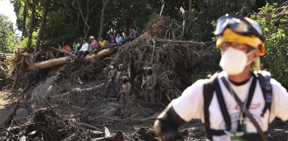 Un rescatista mira frente al tronco de un árbol que cayó durante un deslizamiento de tierra mortal en Nejapa, El Salvador, el viernes 30 de octubre de 2020. (AP Foto/Salvador Melendez)