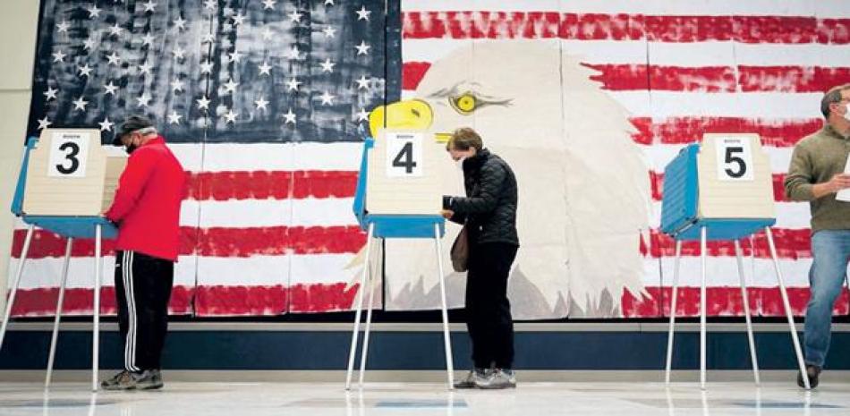 Tres estadounidenses votan durante los comicios generales de ayer en la escuela primaria Robious, en Midlothian, Virginia. Los votantes parecían inclinarse especialmente por la crisis de salud pública como el problema más importante para el país, mientras que la economía se encontraba en un cercano segundo lugar. AP