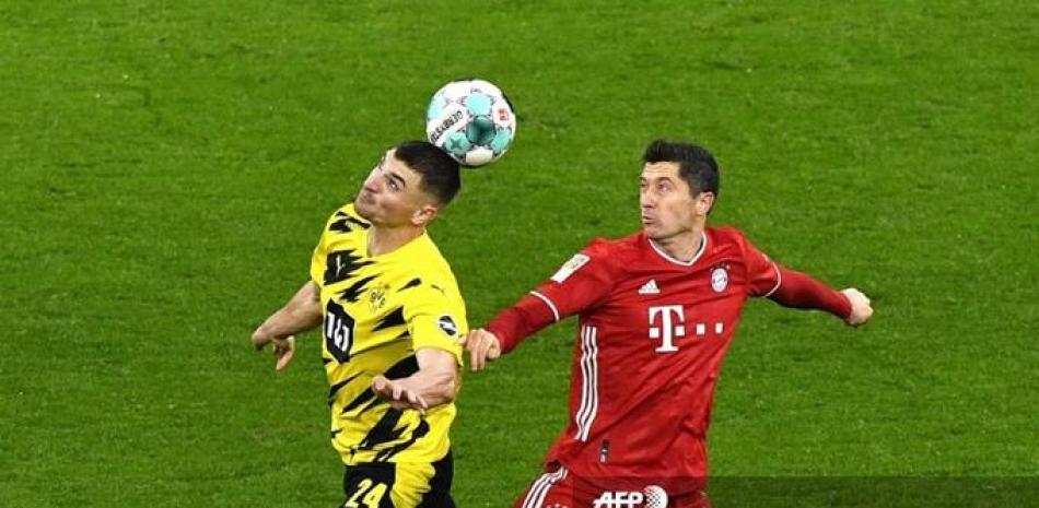 El delantero polaco del Bayern Munich Robert Lewandowski (R) y el centrocampista belga del Dortmund Thomas Meunier disputan el balón durante el partido entre el BVB Borussia Dortmund y el FC Bayern Munich en el estadio Signal Iduna Park en Dortmund, Alemania occidental.