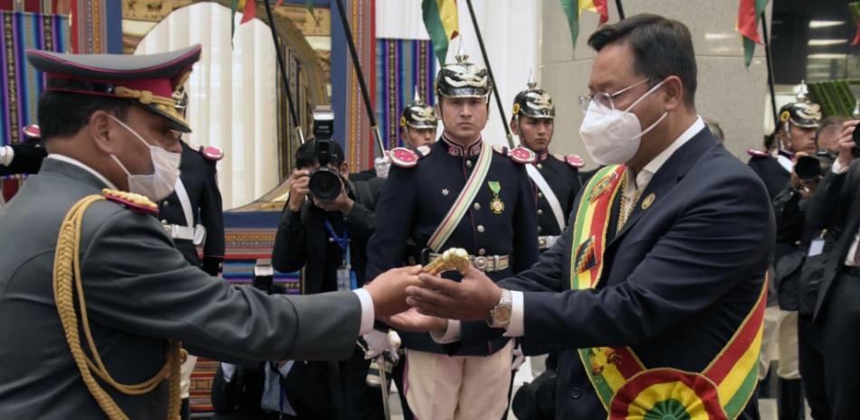 Foto difundida por la Agencia Boliviana de Información (ABI) que muestra al nuevo presidente de Bolivia Luis Arce (derecha) recibiendo la batuta presidencial, en La Paz, el 8 de noviembre de 2020. Enzo de Luca / ABI / AFP