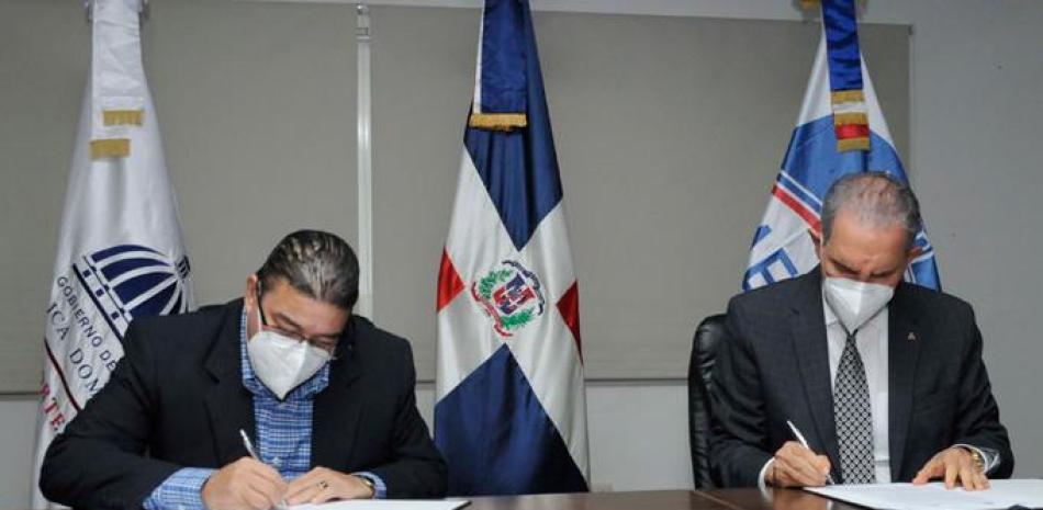 Los ministros de Deportes y Educación Superior, Francisco Camacho y Franklin García Fermín, firman el acuerdo para beneficio de los atletas y sus familiares.