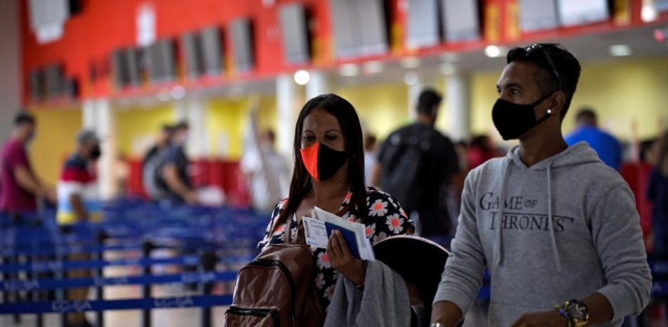 Los pasajeros llegan al Aeropuerto Internacional José Martí al reanudarse los vuelos comerciales en La Habana el 15 de noviembre de 2020, luego de casi ocho meses en medio de la nueva pandemia de coronavirus. 

Foto: AFP.