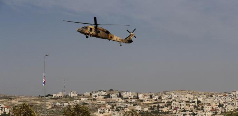 Un helicóptero Blackhawk de la fuerza aérea israelí que transporta al secretario de Estado de los Estados Unidos, Mike Pompeo, se cierne sobre el parque industrial de los colonos de Sha'ar Binyamin cerca del asentamiento israelí de Psagot en la ocupada Cisjordania al norte de Jerusalén el 19 de noviembre de 2020.