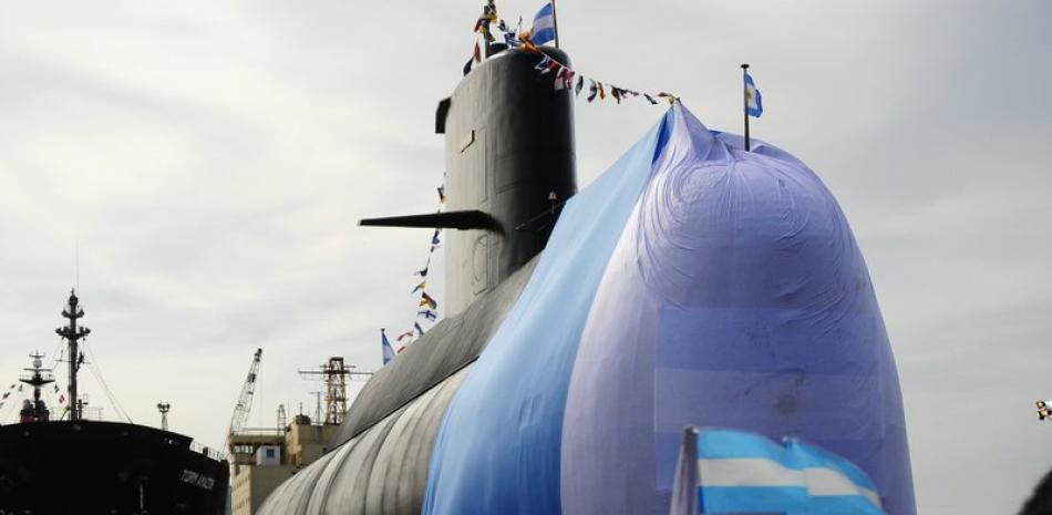 En esta fotografía de archivo del 27 de septiembre de 2011, trabajadores se detienen alrededor del submarino ARA San Juan durante una ceremonia de celebración de la primera etapa de reparaciones importantes en el Complejo Industrial Naval Argentino (CINAR) en Buenos Aires. (AP Foto/Mario de Fina, Archivo)