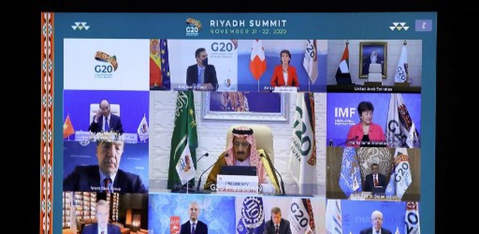 El presidente del Consejo Europeo, Charles Michel (abajo), y el rey de Arabia Saudita, Salman bin Abdulaziz Al Saud, son vistos con otros líderes estatales e institucionales en una pantalla antes del inicio de una cumbre virtual del G20. Foto: Yves Herman/AFP.