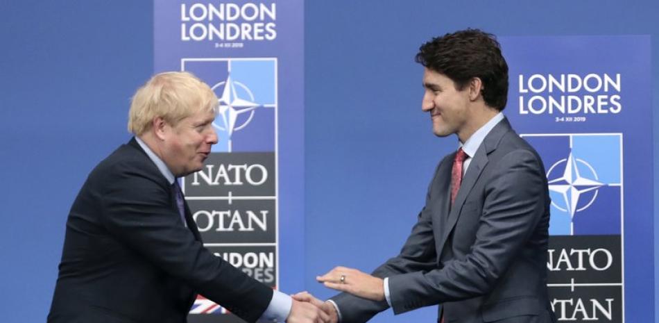 ARCHIVO - En imagen de archivo del miércoles 4 de diciembre de 2019, el primer ministro británico Boris Johnson, izquierda, recibe a su homólogo canadiense Justin Trudeau durante la llegada oficial de líderes de la OTAN en el hotel The Grove, en Watford, Inglaterra. (AP Foto/Francisco Seco, archivo)